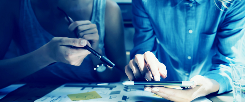 two people, holding a pen and a tablet, working on their affiliate business, depicting affiliate marketing