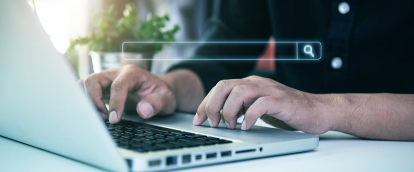 dos manos escribiendo en un ordenador portátil con una barra de búsqueda para insertar un enlace, representando la búsqueda de marketing de afiliación