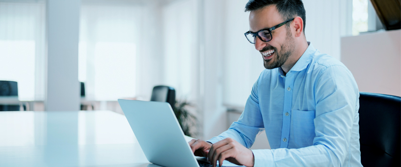 a man wearing glasses and working on his laptop, depicting affiliates and working on affiliate businesses
